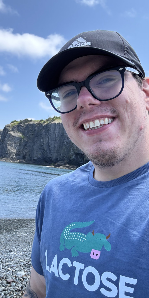 An image of Jesse smiling by the water